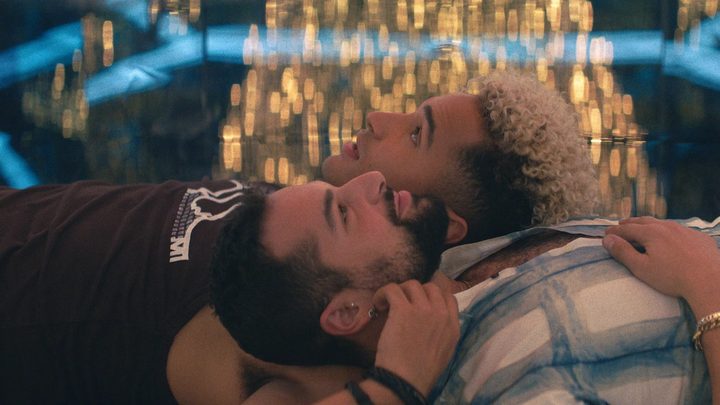 Brodie and Noah lie next to each other in 2022's Queer as Folk.