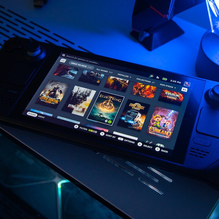 A Steam Deck sitting on top of a PC.