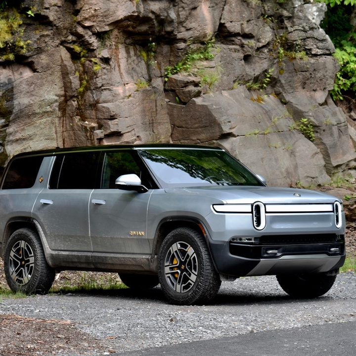 The front three-quarter view of a 2022 Rivian against a rocky backdrop.