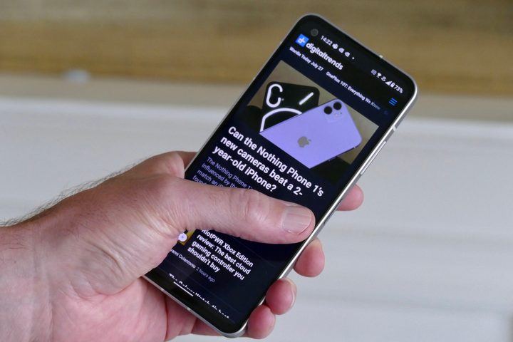 Holding the Asus Zenfone 9 to show how it's able to be used one-handed.