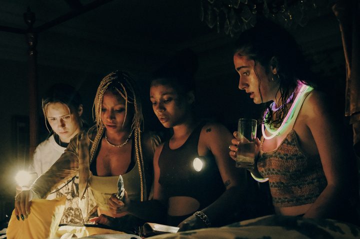Bee, Sophie, Jordan, and Alice stand in the dark together in Bodies Bodies Bodies.