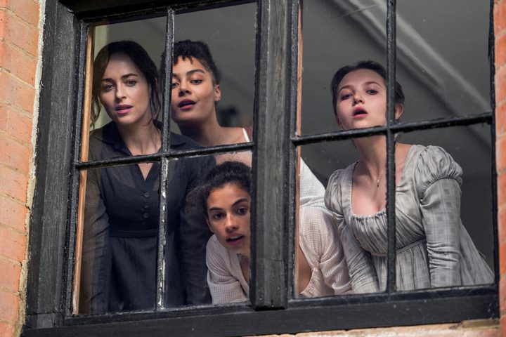The Elliot and Musgrove sisters look through a window together in Netflix's Persuasion.