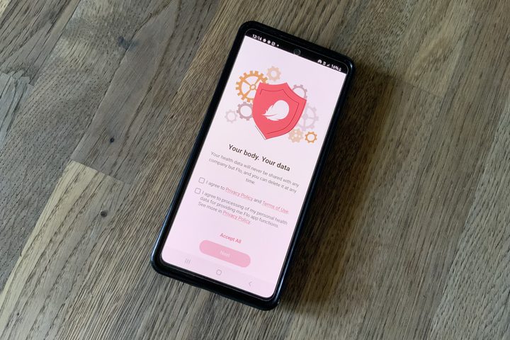 Flo's policies are visible on screen of phone laid on table.