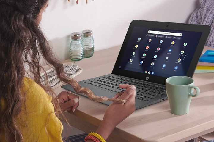 Woman sits at desk using a HP 11.6-inch Chromebook.