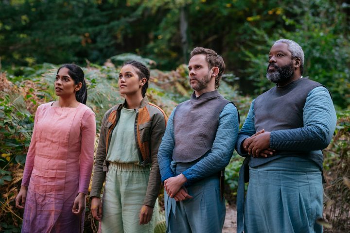 Indira, Bella, Paul, and Arlo all stand outside together in Moonhaven.
