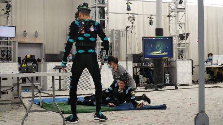 Justice Smith and Miles robbins act out a scene while wearing performance-capture suits on the set of The Quarry game.