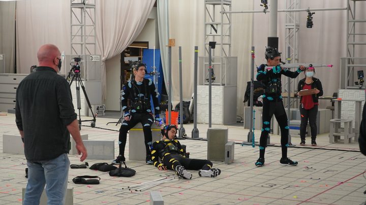 Miles Robbins, Evan Evagora, and Justice Smith act in performance-capture suits on a set for a scene in The Quarry game.