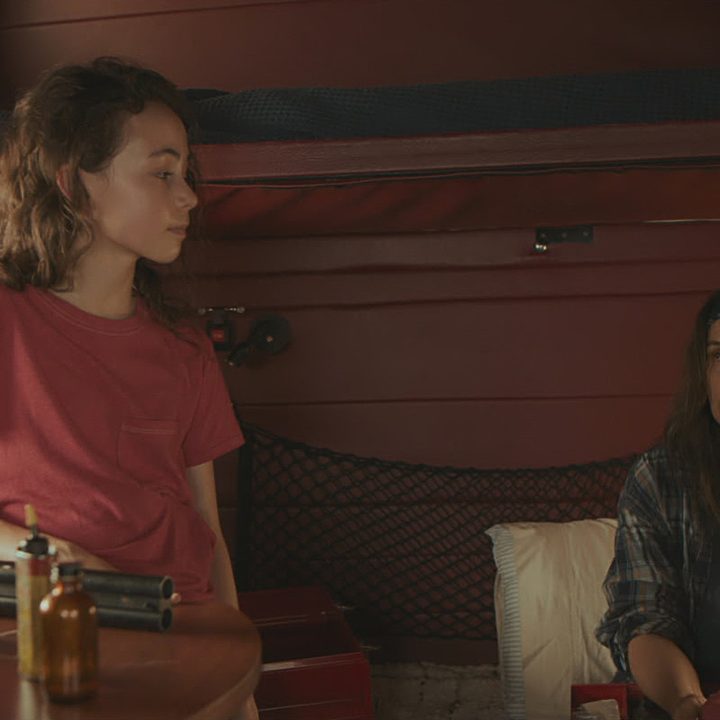 Hala Finley and Juliette Binoche stare at each other and speak in the truck in a scene from Paradise Highway.
