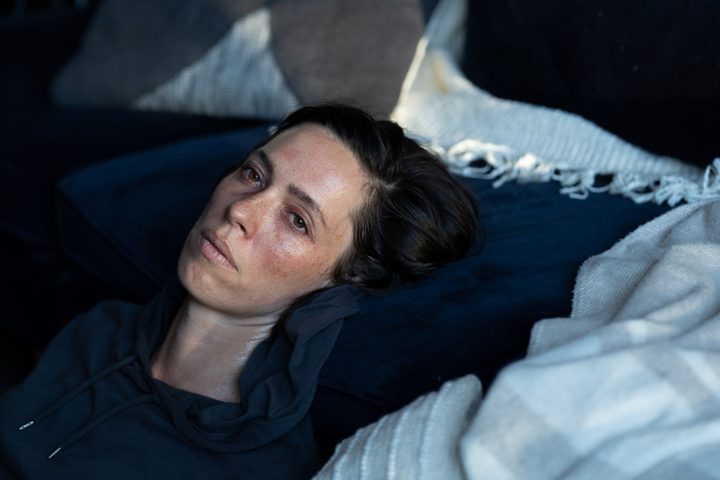 Rebecca Hall rests her head on the edge of a couch in Resurrection.