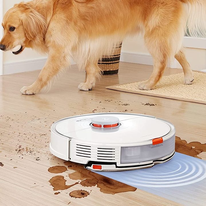 Roborock S7 cleaning a dirty floor with pup nearby.