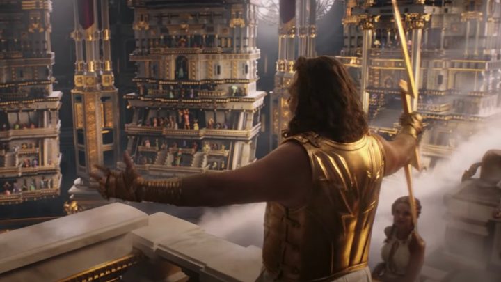 Russell Crowe as Zeus greeting his audience in Omnipotence City in Thor: Love and Thunder.