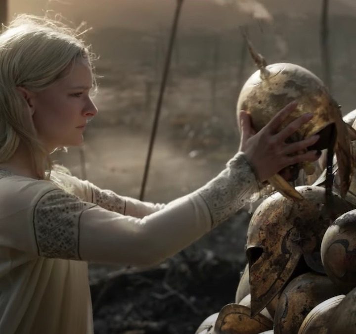 Galadriel putting a helmet on top of a pile in a scene from Lord of the Rings The Rings of Power.
