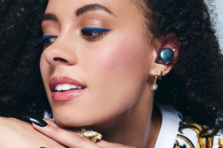A woman wearing the UE Drops custom-fit wireless earbuds.