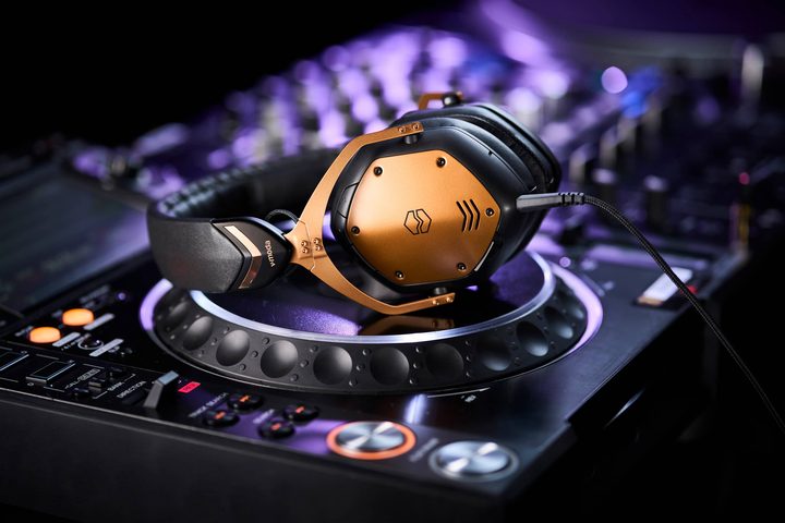 Bronze V-Moda Crossfade 3 Wireless headphones on DJ console turntable.