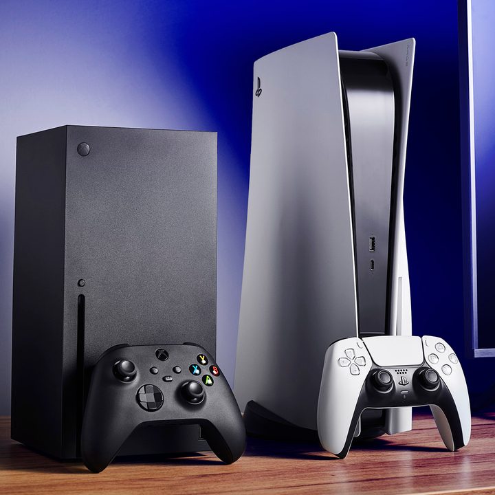 Living room with Microsoft Xbox Series X (L) and Sony PlayStation 5 home video game consoles alongside a television and soundbar.