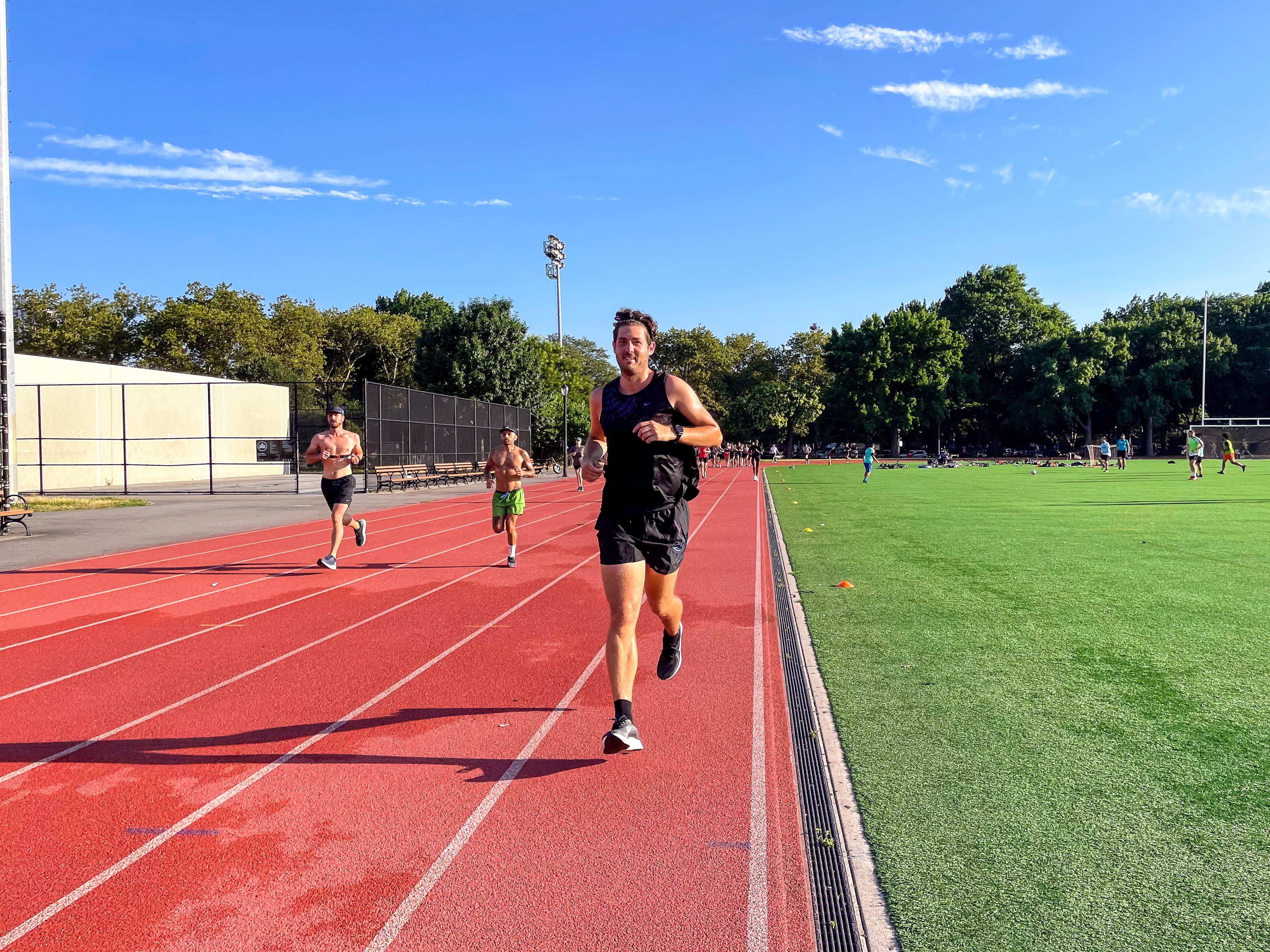 A person running on a track with a Garmin watch.