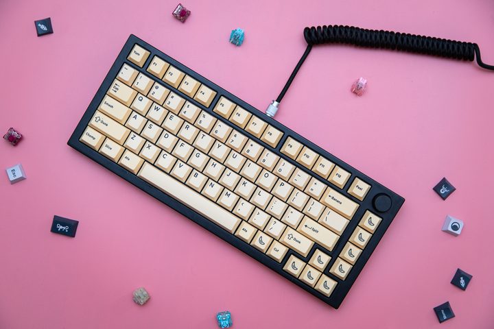 A custom keyboard sitting among keycaps and switches.