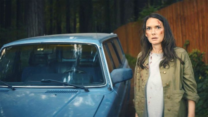 Winona Ryder stand next to a blue car in Gone in the Night.