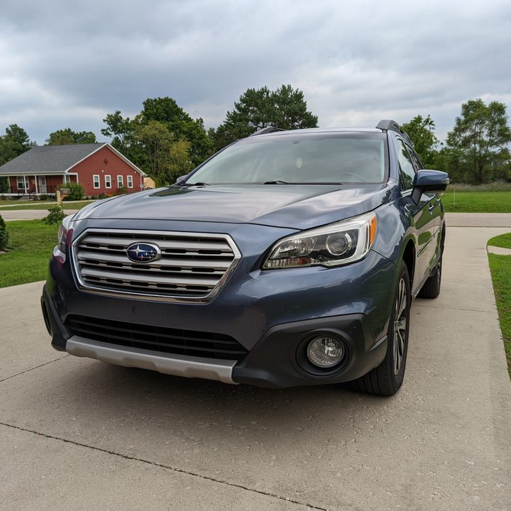 A photo of a blue Subaru Outback in a parking lot.