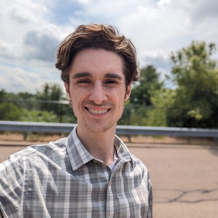 A selfie of Joe Maring. He's standing outside, smiling, and wearing a green button-down shirt.