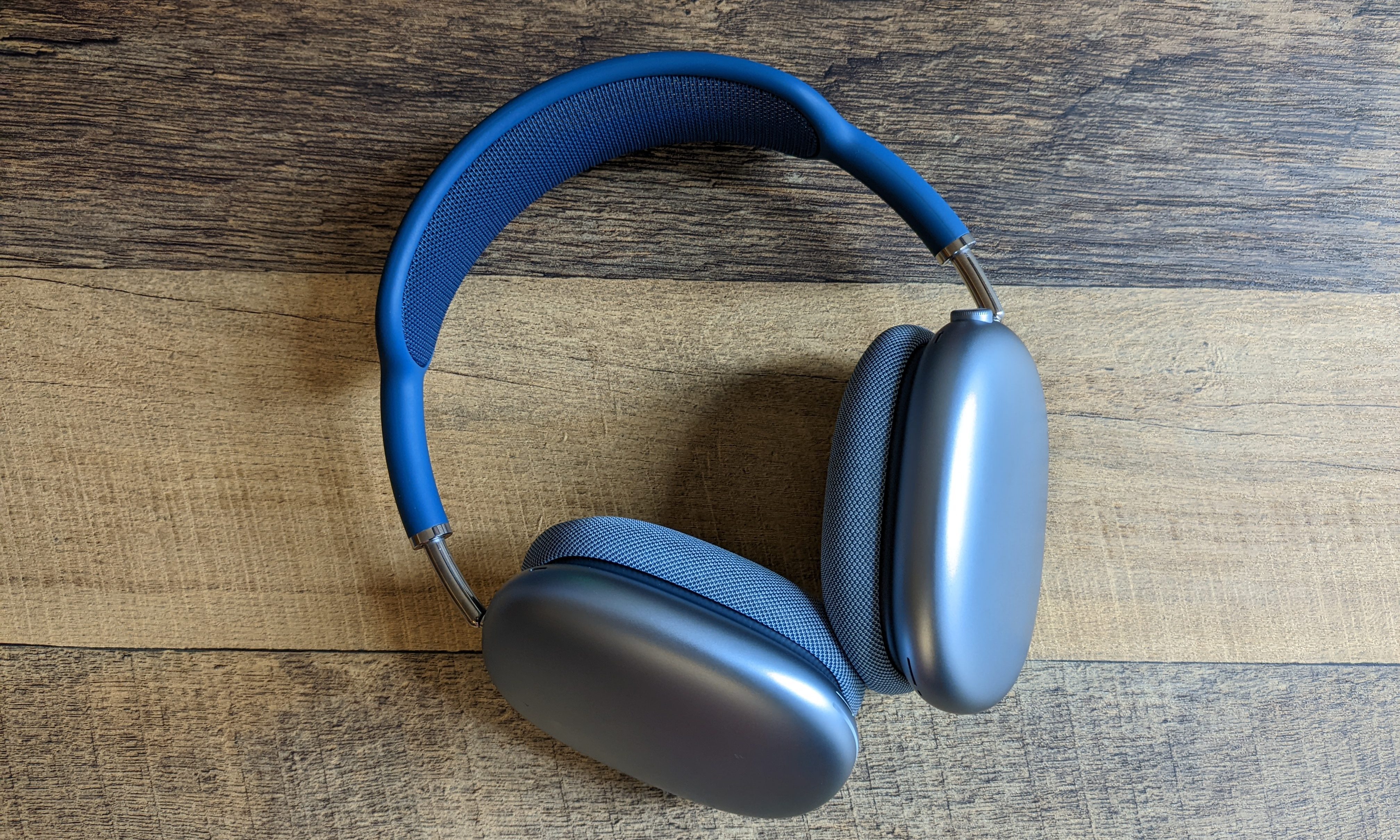 A pair of blue AirPods Max sitting on a table.
