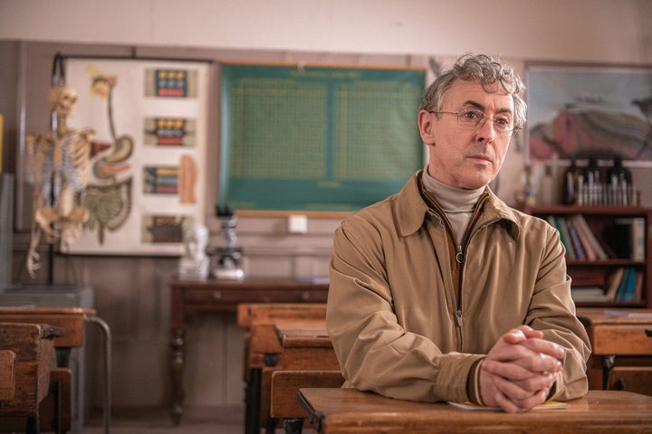 Alan Cumming sits at a school desk in My Old School.
