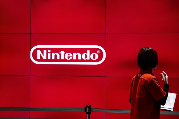 An employee walks past a logo of Japan's Nintendo Co. at a Nintendo store in Tokyo.