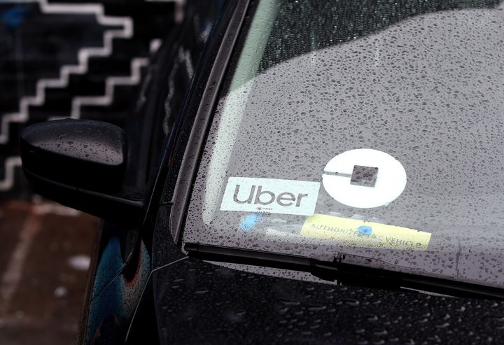 An Uber sticker is visible in the window of a car.