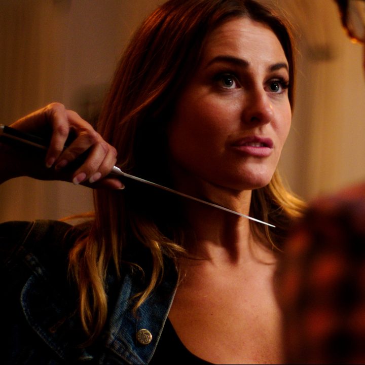 A woman holds a knife to her throat in a scene from Allegoria.