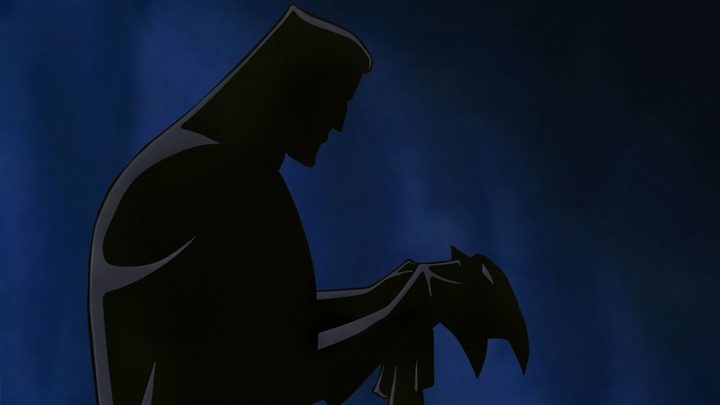The shadowy silhouette of Bruce Wayne donning the Batman mantle.