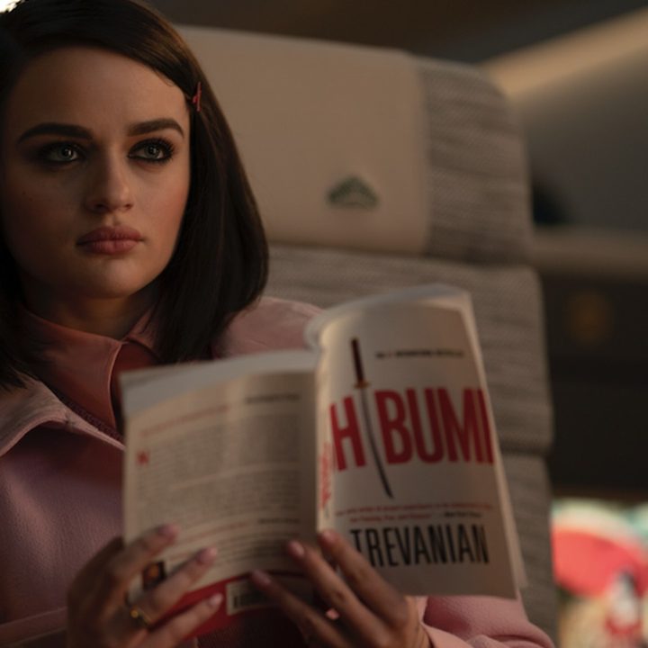 Joey King looks up from book.