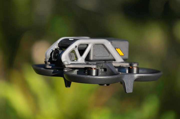 Side view of the DJI Avata flying in a forest.