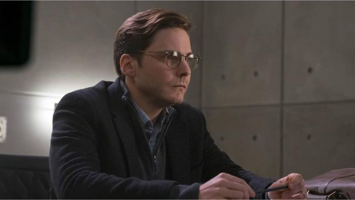 Helmut Zemo sitting down and looking attentively in Captain America: Civil War.