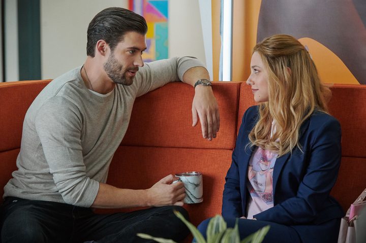 David Corenswet and Lili Reinhart sit on a couch together in Look Both Ways.