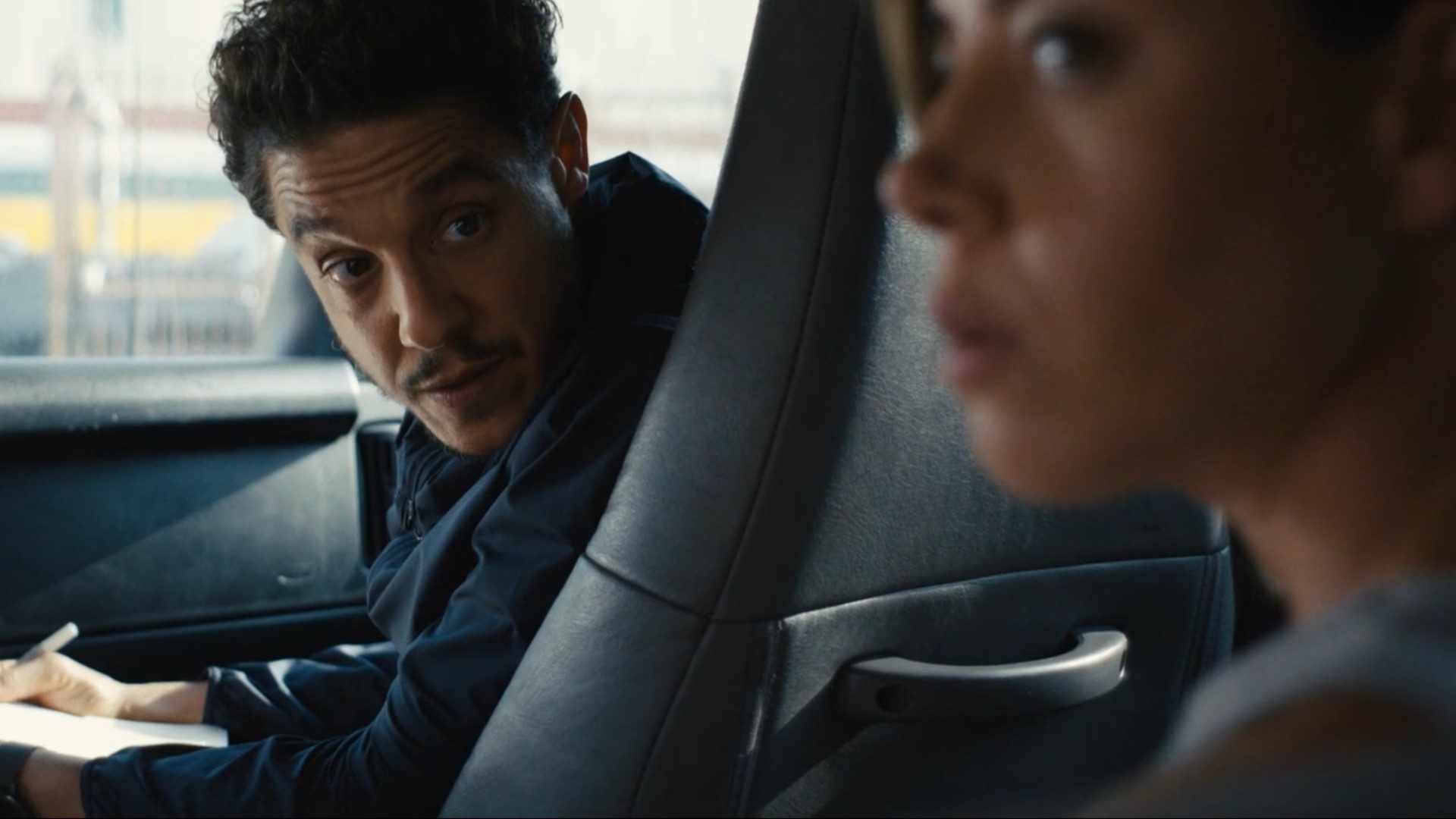 Theo Rossi looks back at Aubrey Plaza in a van.
