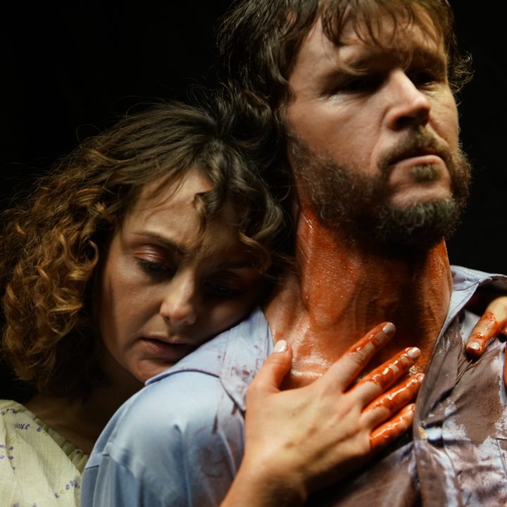 Sylvia Grace Crim holds a bloody Ryan Kwaten from behind in a scene from Glorious.