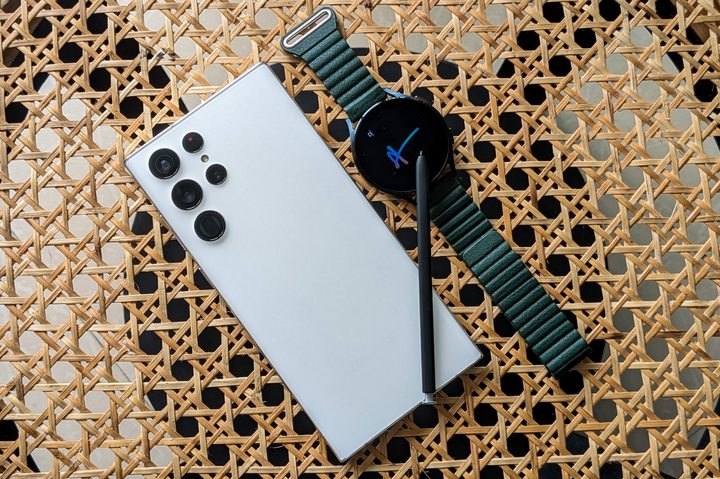 Samsung Galaxy Watch 4 with S Pen from Galaxy S22 Ultra on a cane table background.