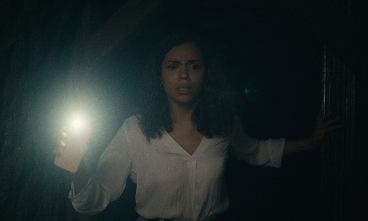 Georgina Campbell holds up her phone in a dark tunnel in "Barbarian."