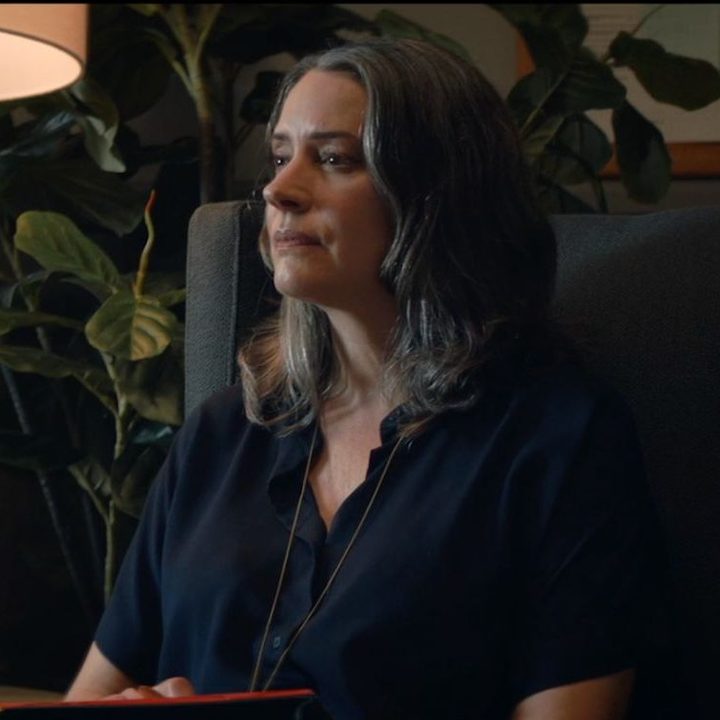 Paget Brewster sitting down and listening in a scene from Hypochondriac.