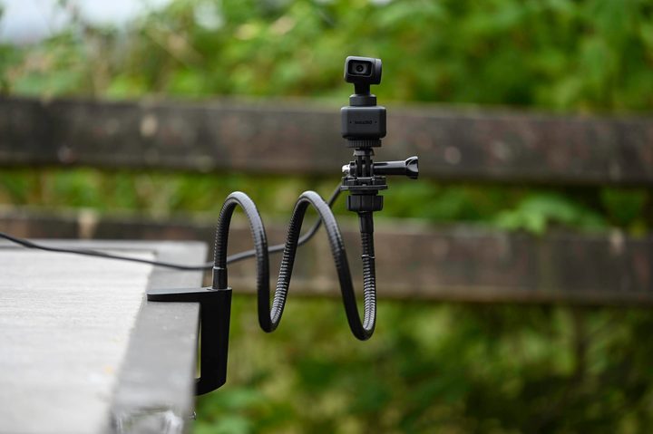 The Insta360 Link attached to a tabletop with a prehensile arm.