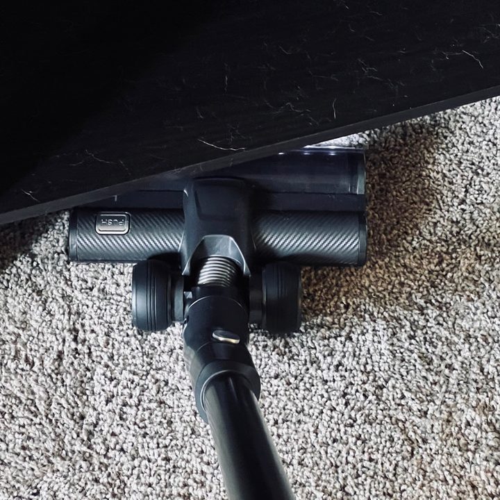 The Levoit VortexIQ 40 cleaning underneath some furniture.