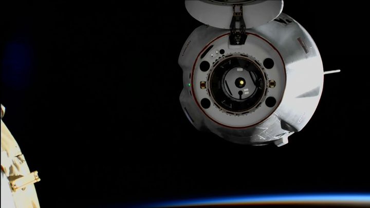 The SpaceX Dragon cargo craft backs away from the space station moments after undocking from the Harmony module’s forward port during an orbital sunrise.