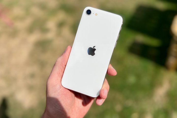 iPhone SE (2022) held in a mans hand.