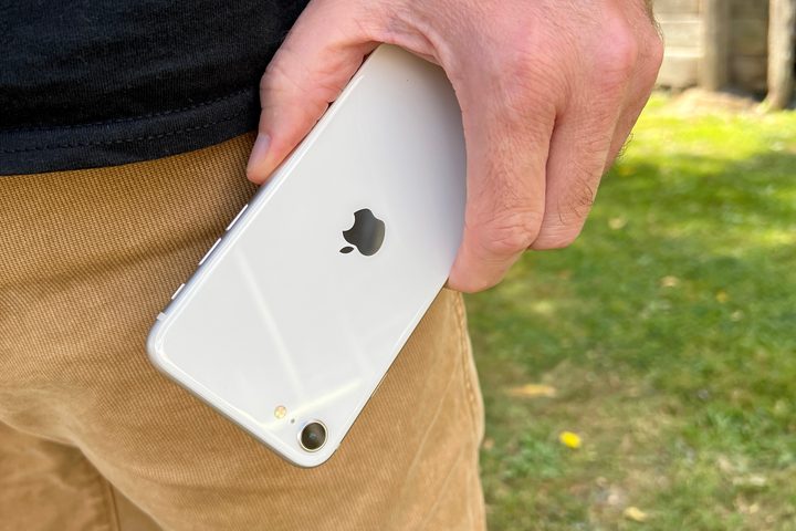 iPhone SE (2022) held in a mans hand.