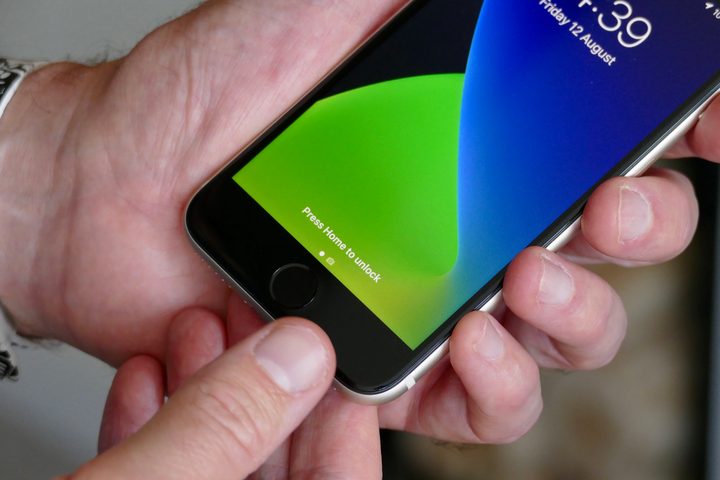 Apple iPhone SE (2022) Touch ID button being used.