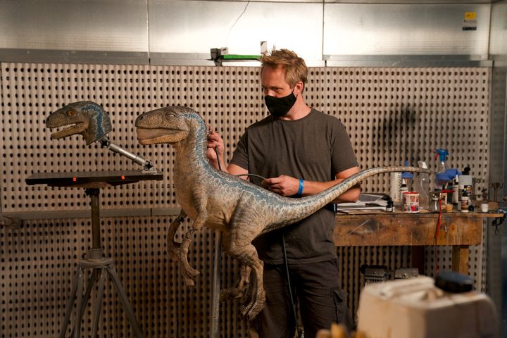 A sculptor works on a dinosaur model for Jurassic World Dominion.