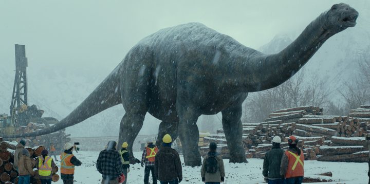 A large dinosaur walks through a construction site in a scene from Jurassic World Dominion.