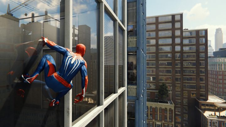 Peter Parker hanging on a building in Marvel's Spider-Man.