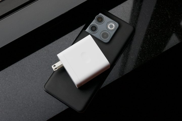 A white charger sitting on top of the black OnePlus 10T.
