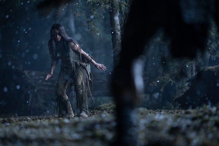 Amber Midthunder gets ready to fight, facing the camera, in a night scene from Prey.